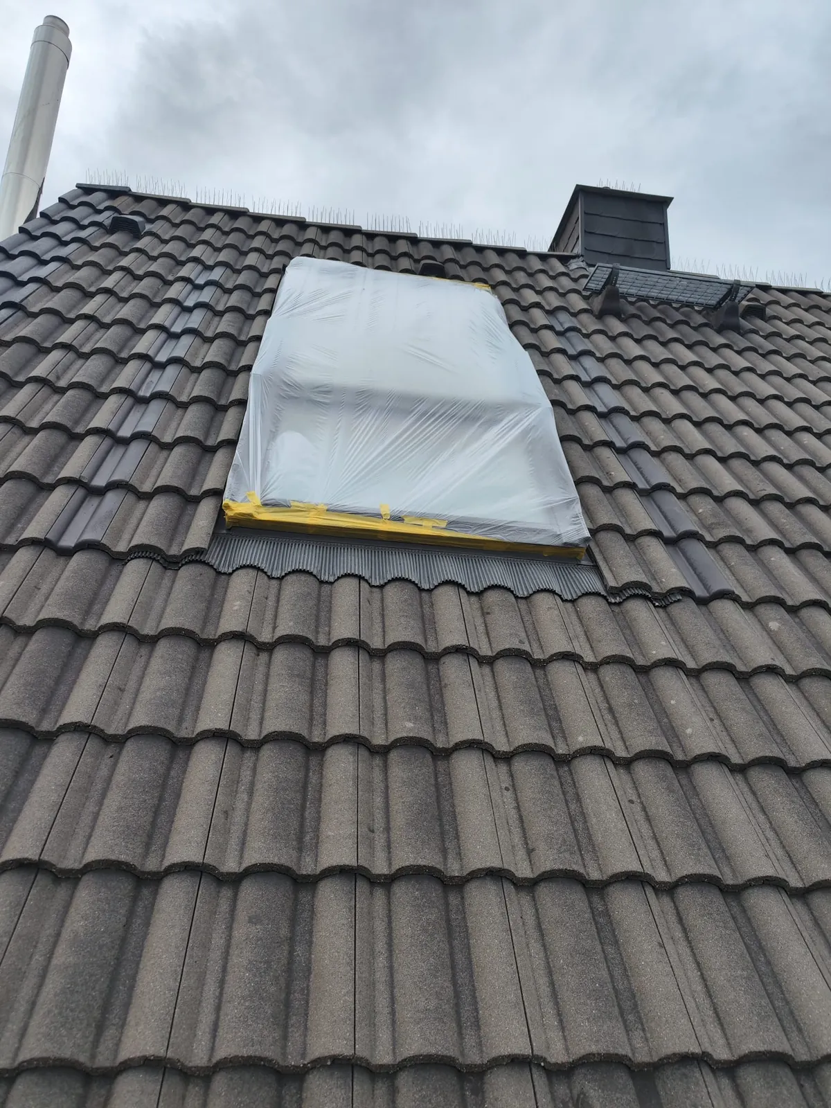 Dachfläche vor dem Sprühen: Fenster und Anschlüsse sind sorgfältig mit Folie und Klebeband abgeklebt